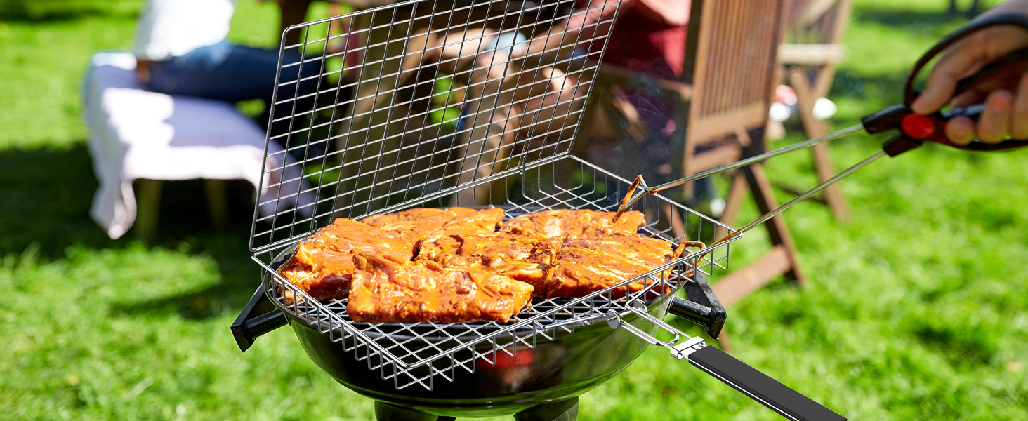 Grilling basket filled with marinated meat over charcoal grill, outdoors on grass.