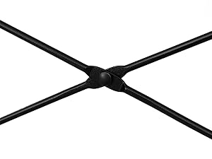 Primer plano de una estructura metálica negra en forma de X. Cuatro brazos se extienden desde una articulación central, formando una cruz o forma de X.