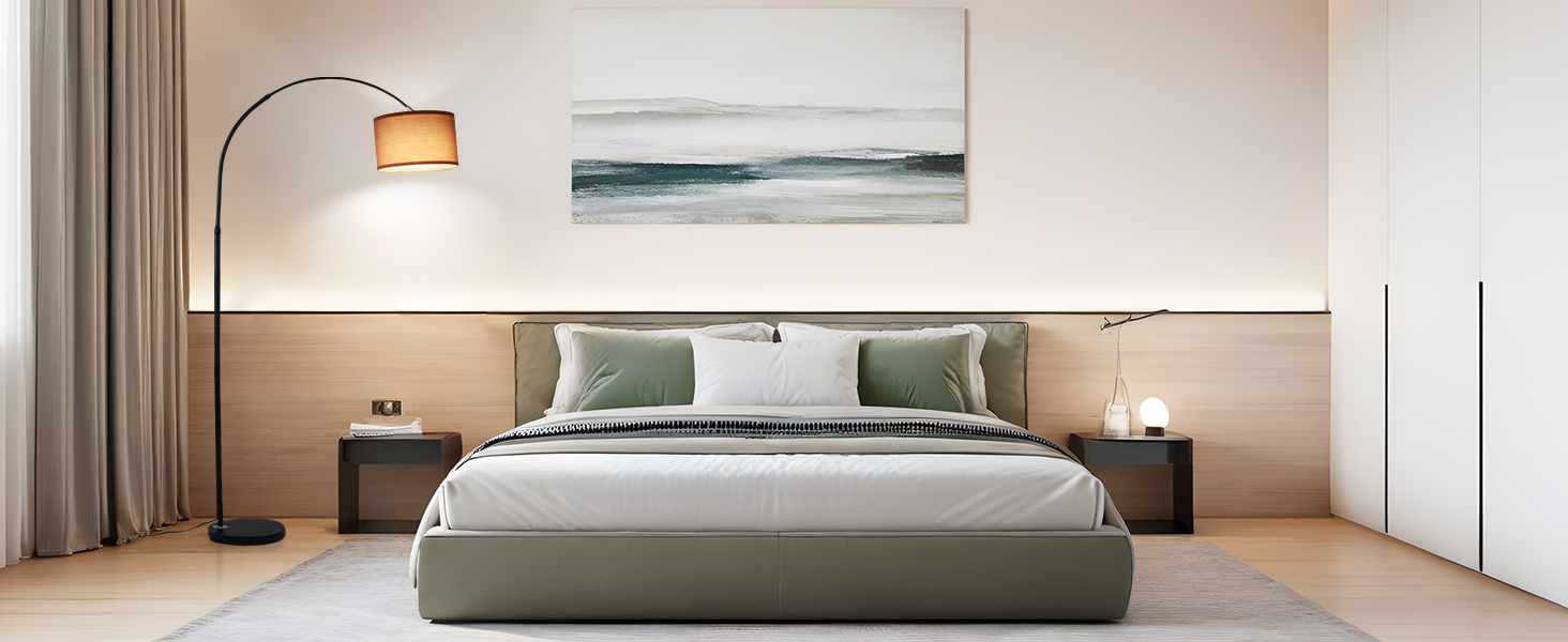 Modernes Schlafzimmer mit grünem Polsterbett, weißer Bettwäsche, Holzkopfteil, gewölbter Stehlampe und Wandkunst mit Meeresmotiven. Minimalistisches Design