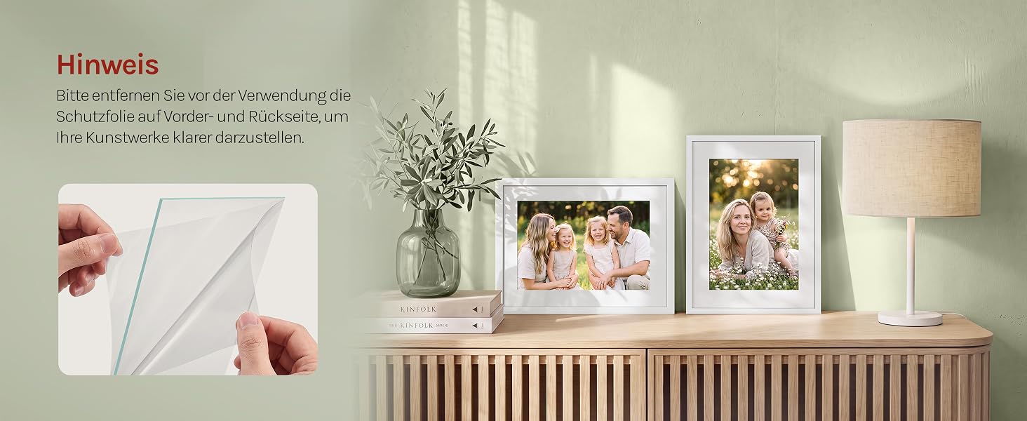 Der Text lautet „Hirewells“. Deko-Display mit floralen Kunstdrucken auf weißen Rahmen, montiert an einer salbeigrünen Wand über einem Holzlattenregal mit Vasen und Lampe.