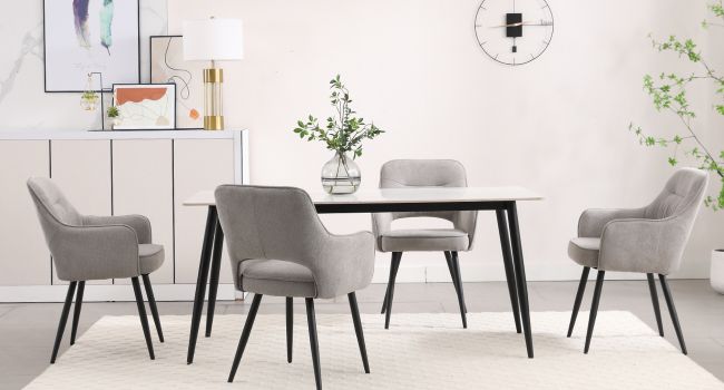Moderne Essgruppe mit rechteckigem schwarzem Tisch mit vier grauen gepolsterten Stühlen, eingerichtet in einem minimalistischen Raum mit Wandkunst und Pflanzendekor.