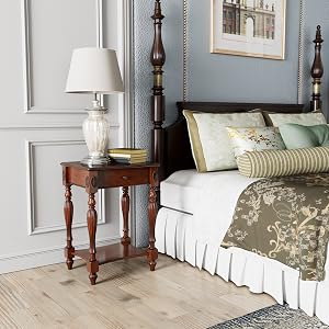 Schlafzimmerecke mit Himmelbett, Nachttisch aus Holz, weißer Lampe und dekorativen Kissen. Blaue Wände und Holzböden sorgen für eine gemütliche Atmosphäre