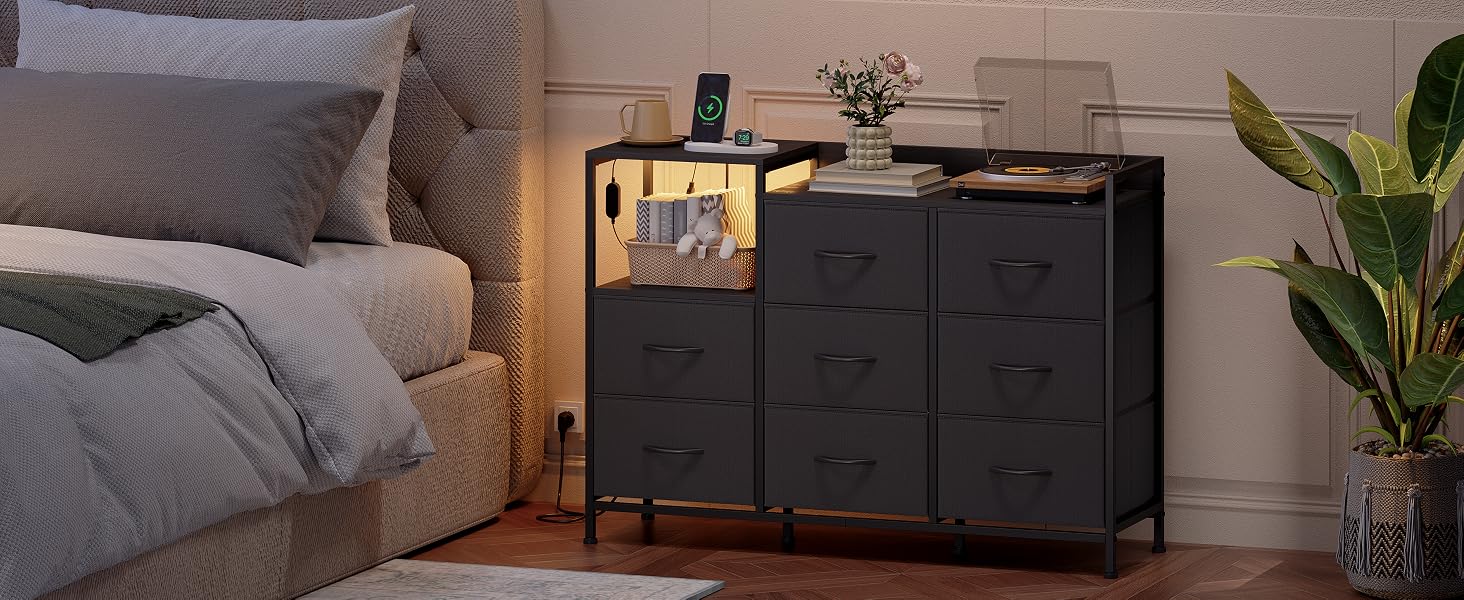 Trois scènes intérieures montrant des unités de rangement modulaires noires sur des murs gris, décorées avec des plantes d'intérieur et placées à côté de canapés gris.