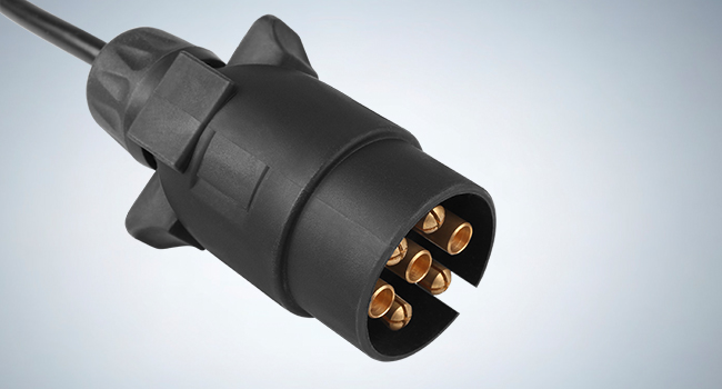 Black plastic electrical connector with 7-pin configuration, featuring cylindrical design and gold-plated contact points.