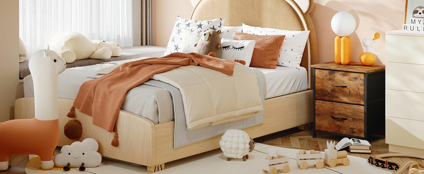 Intérieur de chambre confortable avec literie beige, couverture en terre cuite, table de chevet en bois, lampe de table et animaux en peluche décoratifs.