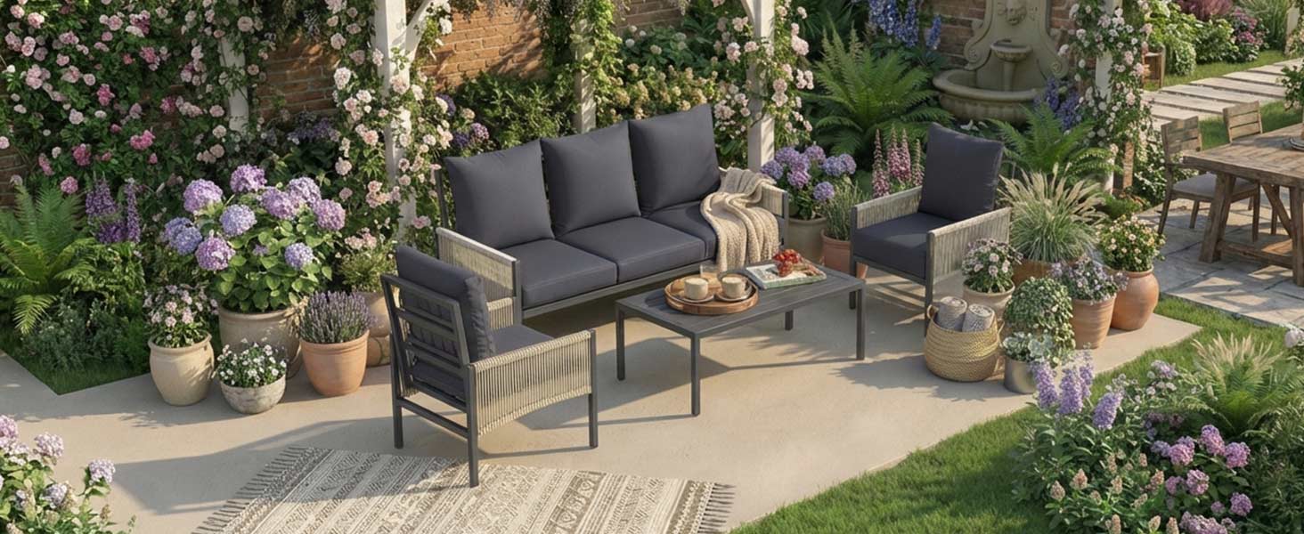 Outdoor patio furniture set featuring dark-colored seating arrangement surrounded by potted plants and garden decor on stone paving.