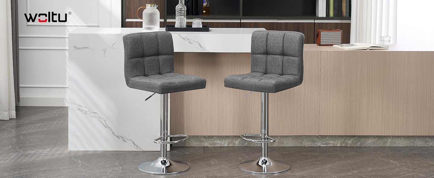 Interior moderno de oficina o sala de conferencias con elegantes sillas a la altura de una barra y una mesa contra paneles de pared con mechones grises en la pared.