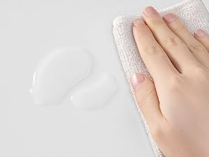 Primer plano de las manos con guantes protectores blancos sobre un fondo gris claro, que demuestra el equipo de protección de manos adecuado.
