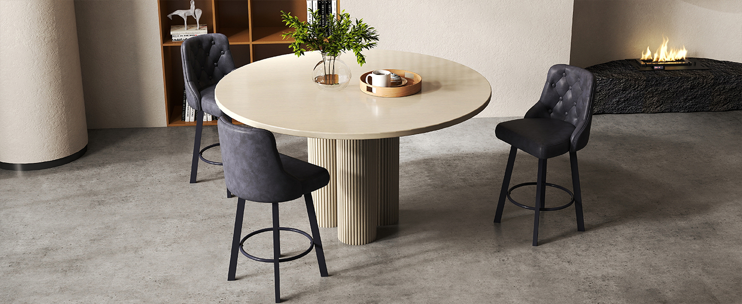 Modern minimalist dining area with round white table and black chairs on a concrete floor in what appears to be an industrial-style space.