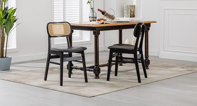 Rustic dining set with wooden table and two black chairs on light-colored area rug in bright white room.