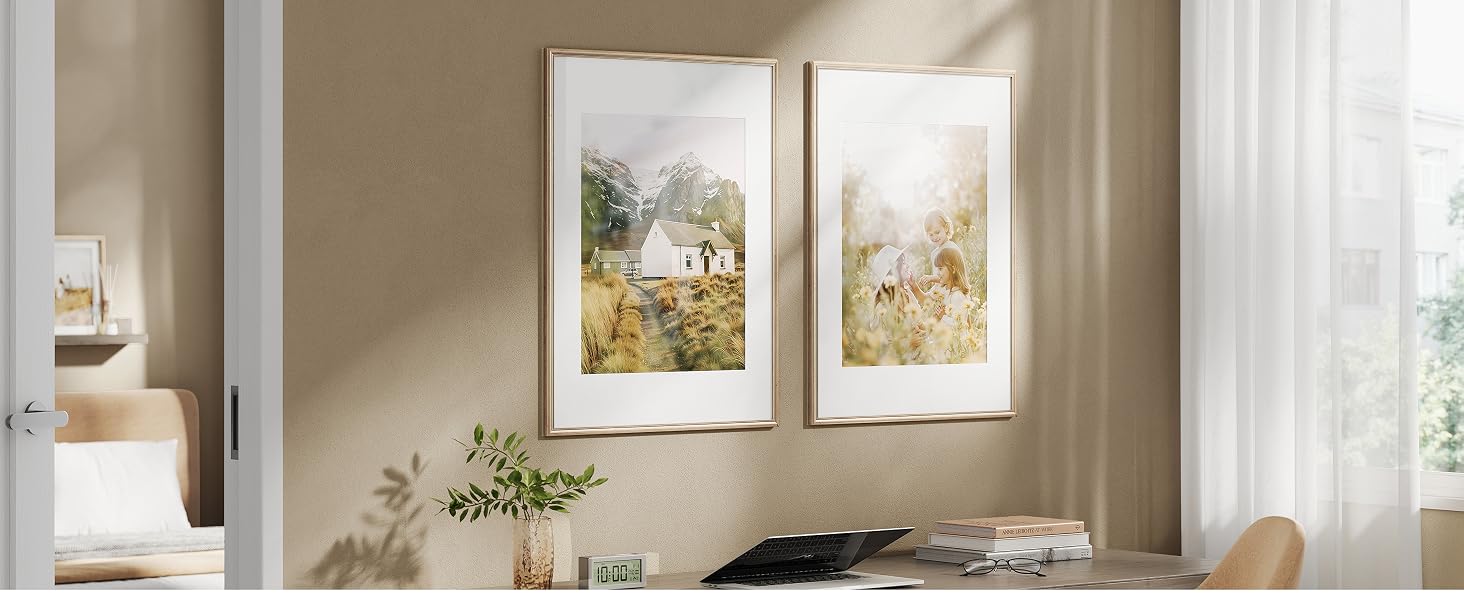 Obras de arte enmarcadas que se muestran en un entorno interior luminoso con paredes blancas y tratamientos en las ventanas. Obras de arte dispuestas en una configuración tipo galería.