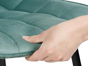 Primo piano della superficie trapuntata color verde acqua pressata a mano, che dimostra la morbidezza e l'imbottitura