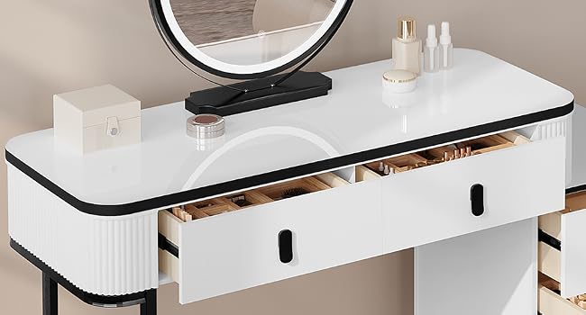 blanco con estructura de metal negro, con cinco cajones, un gran espejo circular y una superficie superior plana. Se muestra en un entorno de dormitorio