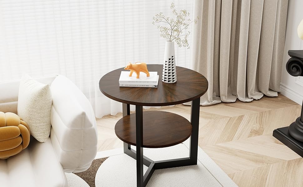 Runder Beistelltisch aus Holz mit zwei Ebenen und schwarzem Metallrahmen, der auf einem gemusterten Teppich neben einem weißen Sofa und beigen