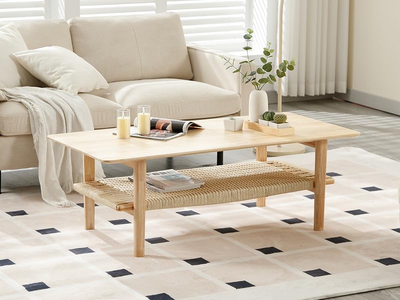 Modernes Wohnzimmer mit beigem Sofa, Couchtisch aus Holz mit geflochtenen Rattandetails und schwarz-weißem Fliesenboden.