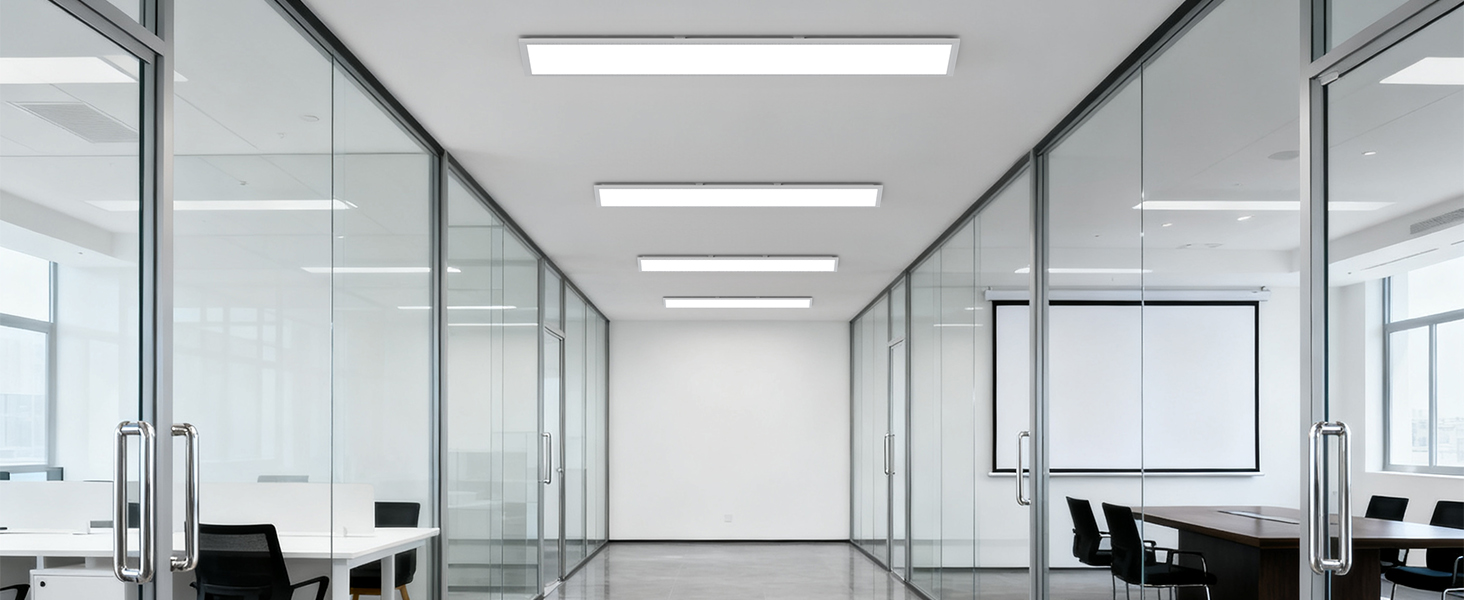 Modernes Bürointerieur mit weißen Wänden und heller Beleuchtung. Mehrere gut sichtbare Arbeitsplätze mit klarem, minimalistischem Design und großer Projektionsfläche.