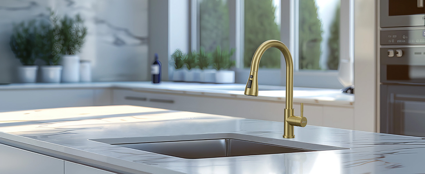Modern kitchen featuring a brass or gold-finished faucet and undermount sink, set in a light-colored countertop near a bright window.