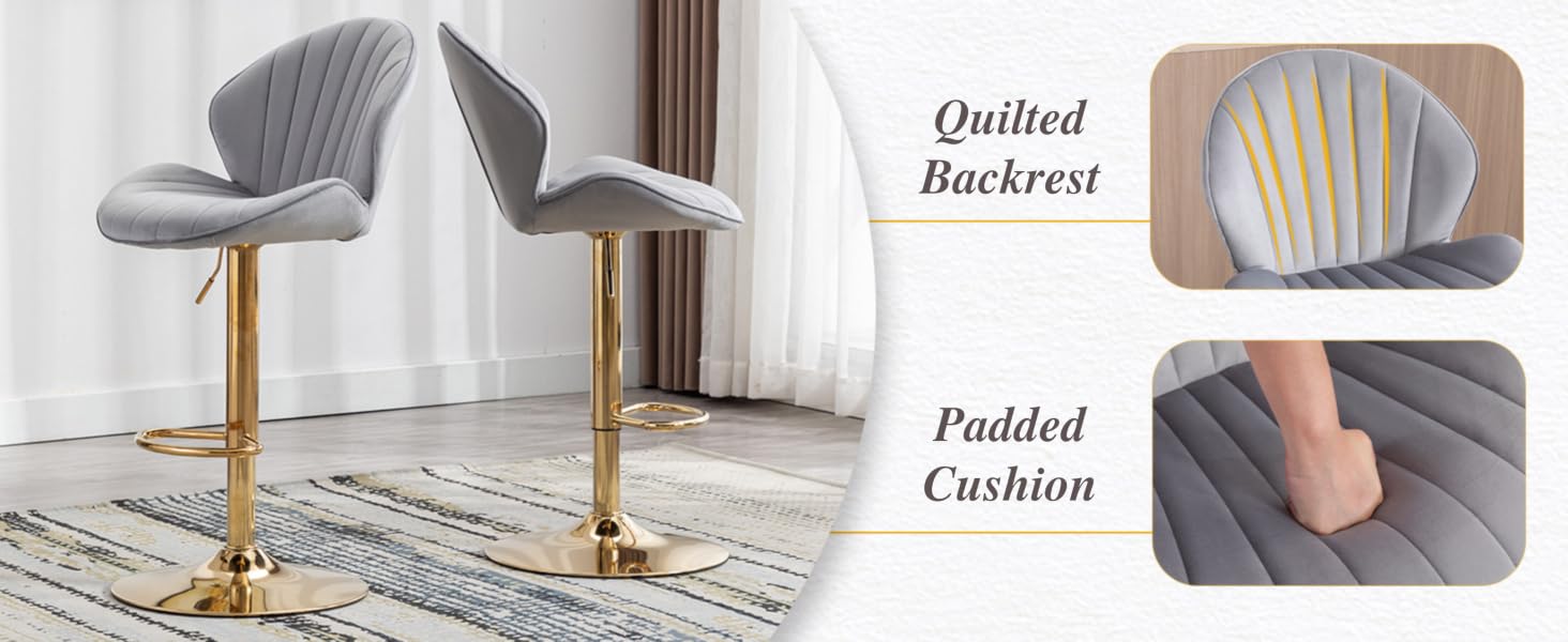 Gray upholstered bar stools with quilted backrest, padded cushion, and gold-tone metal base. Features adjustable height and 360-degree swivel. Shown in a living room setting.