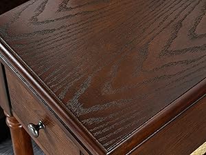 Gros plan d'une surface de meuble en bois brun foncé avec une finition brillante ou polie, montrant la texture du grain et la brillance.