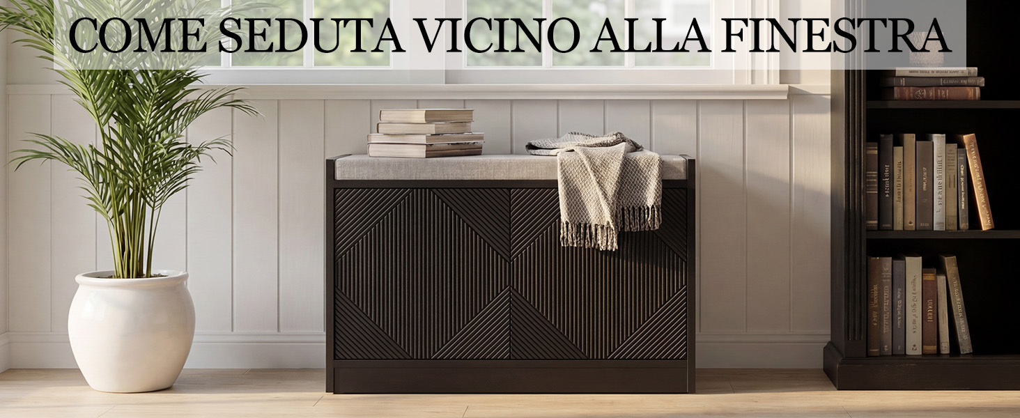 Il testo recita 'COME SEDUTA VICINO ALLA FINESTRA'. Immagine di design degli interni che mostra un vaso bianco con fiori su una credenza scura appoggiata su uno scaffale.