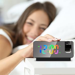 une femme tenant une horloge numérique au lit