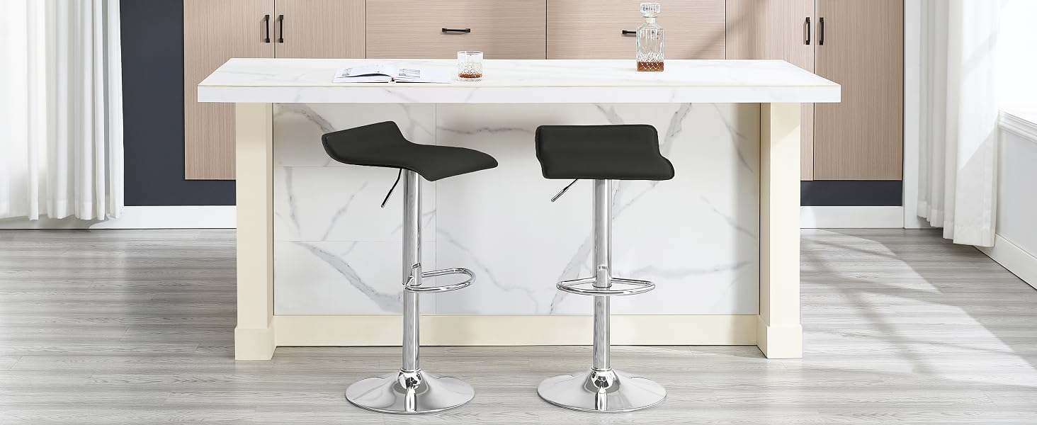 Modern kitchen island with white countertop and two black adjustable-height bar stools featuring chrome bases, set against gray wood flooring.