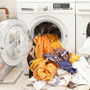 une pile de vêtements est entassée dans une machine à laver