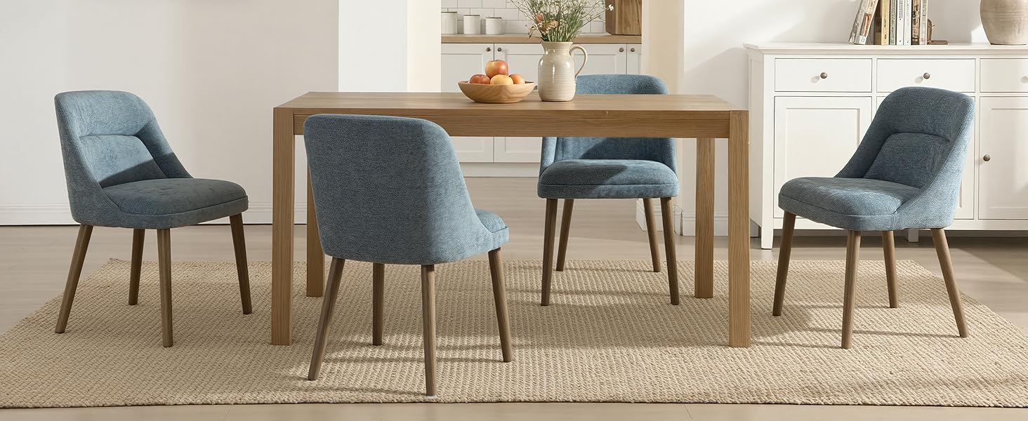 Collection of modern accent chairs in light blue/grey upholstery with wooden legs, arranged in a showroom setting on beige carpet.