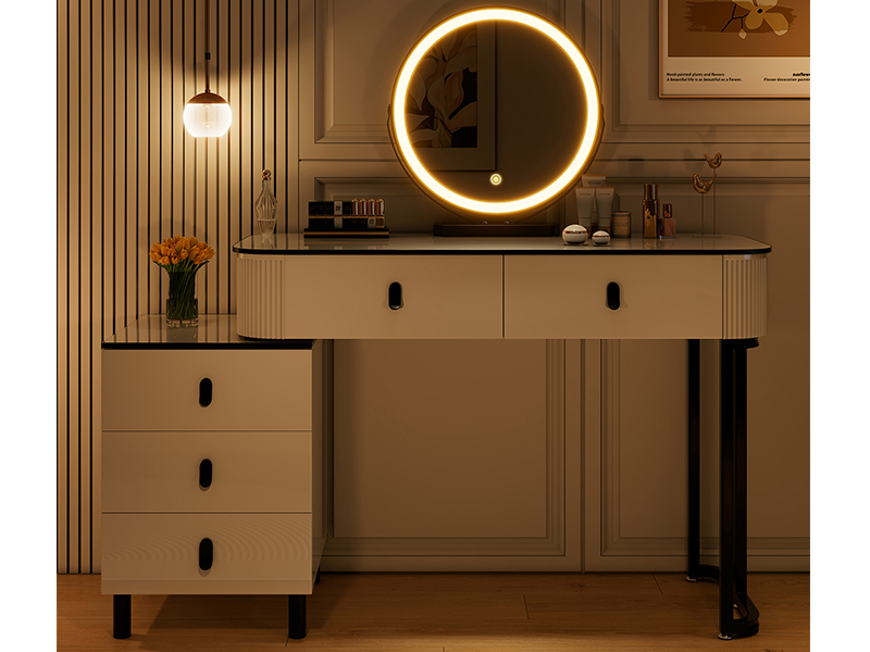 Modern vanity desk with illuminated circular LED mirror, featuring white drawers, black handles, and wooden slat wall backdrop. Warm ambient lighting creates cozy atmosphere.