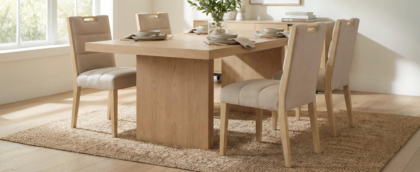 Moderno set da pranzo composto da un tavolo rettangolare in legno chiaro con sedie imbottite abbinate nei toni del beige, posizionate vicino a una finestra.