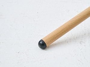 Cheville en bois avec finition lisse et embout sphérique foncé sur surface blanche. Poteau cylindrique en bois, vue détaillée rapprochée.