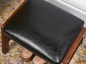 Ein Paar Schuhe sitzt unter einem Hocker.
