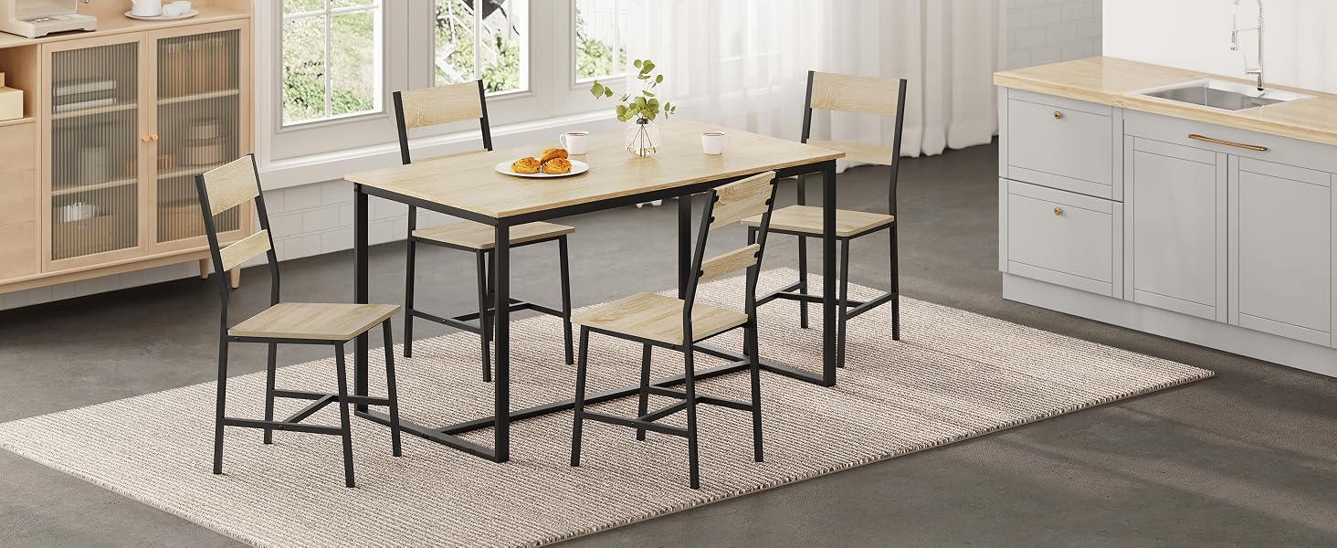 Modern kitchen interior with white cabinets, marble-top dining table, and black metal chairs on a geometric patterned area rug.