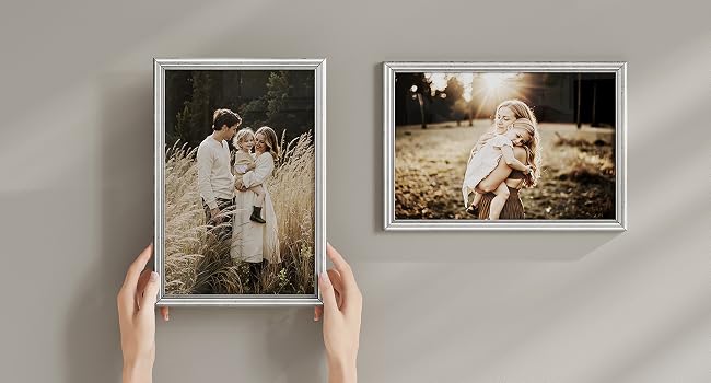 Serie di immagini che mostrano opere d'arte o foto incorniciate installate o disposte su una parete grigio chiaro.