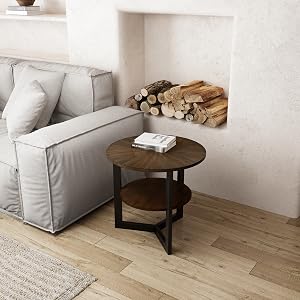 Wohnzimmerecke mit hellgrauem Sofa, rundem Holzbeistelltisch und gestapeltem Brennholz. Beigefarbene Wände und Holzböden sichtbar