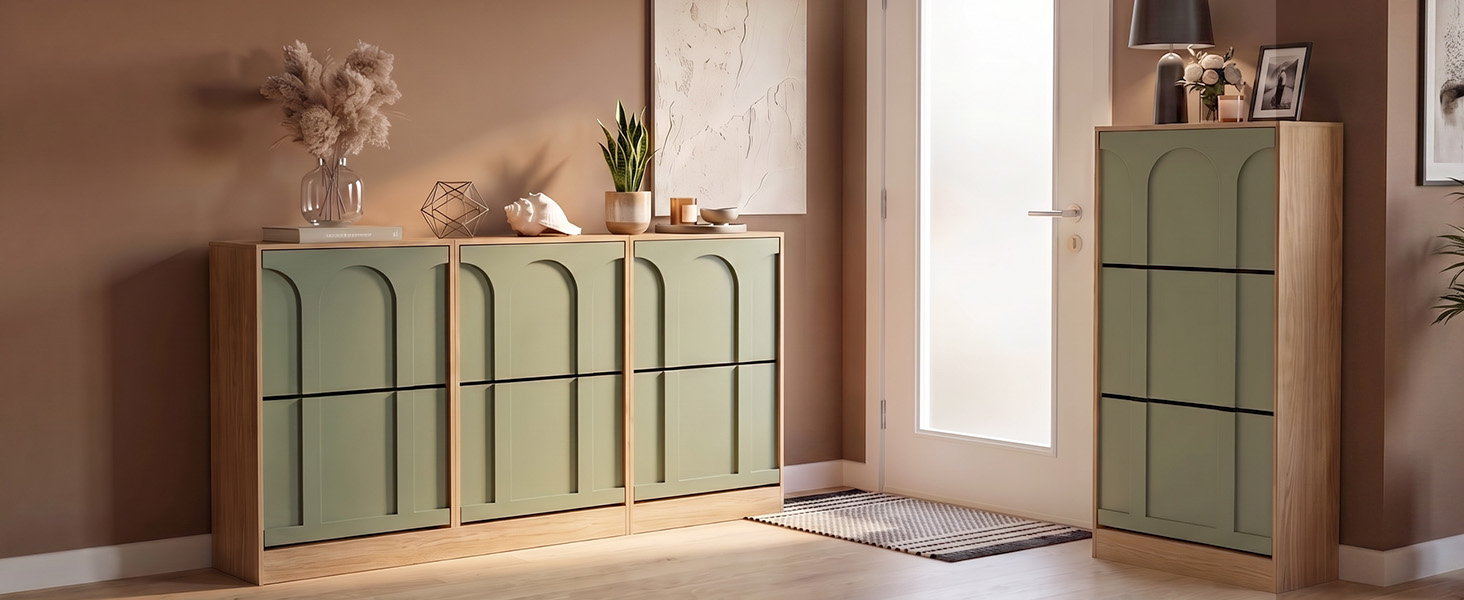 Intérieur moderne avec deux armoires de rangement vert sauge avec détails en panneaux verticaux sur les pieds, positionnées contre des murs neutres dans un décor minimaliste.