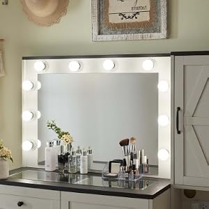 Station de maquillage Vanity avec miroir illuminé, armoires blanches et comptoir noir. Plusieurs vues montrant le rangement des tiroirs et la configuration de l'éclairage avec des ampoules rondes.