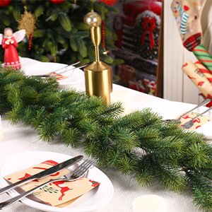 comprenant une guirlande verte, des ornements dorés et des cadeaux emballés sur une surface blanche avec des motifs festifs visibles