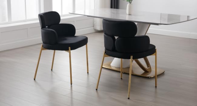 Sillas de comedor modernas con tapicería de terciopelo negro y patas de metal con acabado dorado, dispuestas alrededor de una mesa de comedor con tapa de cristal