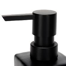 Gros plan du dessus de pompe d'un distributeur de savon en plastique noir, montrant un corps cylindrique et un bec plat et incliné