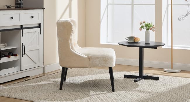Comedor moderno con silla decorativa tapizada en color crema con respaldo capitoné y patas negras, combinada con una mesa redonda de bistró negra. Armario blanco visible en el fondo.