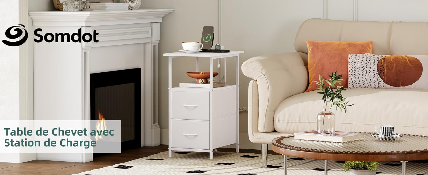 Le texte indique « Somdot », « Table de chevet avec station de charge ». Table de chevet blanche avec borne de recharge intégrée à côté d'un canapé beige avec coussins orange et blanc et décor de plantes en pot.