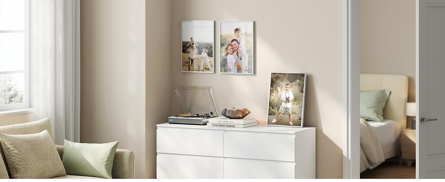 Diseño de pared de la galería que muestra múltiples obras de arte y fotografías enmarcadas dispuestas en una pared blanca en un espacio interior.