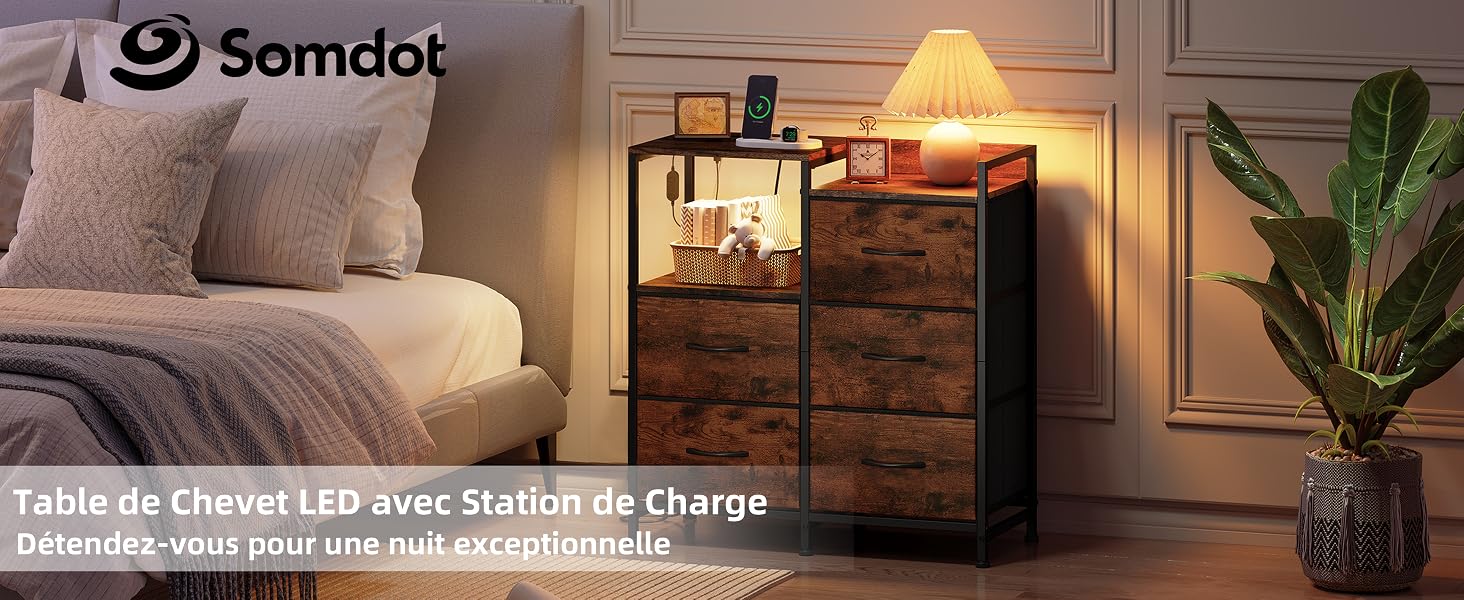 Le texte indique « Somdot » et « Table de chevet LED avec station de charge ». Table de chevet en bois avec lampe LED intégrée et station de recharge à côté du lit avec oreillers et plantes en pot.