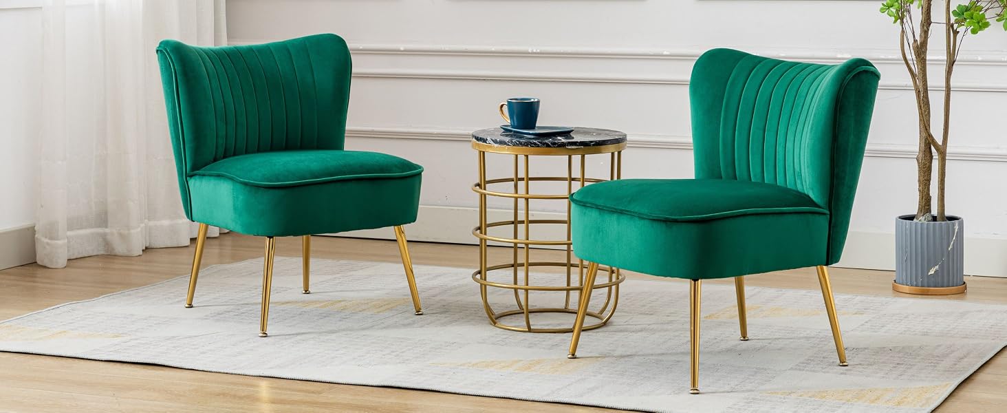 Deux fauteuils d'appoint en velours vert émeraude avec capitonnage à canaux verticaux et pieds dorés, flanquant une petite table d'appoint ronde dorée posée sur un tapis de couleur claire