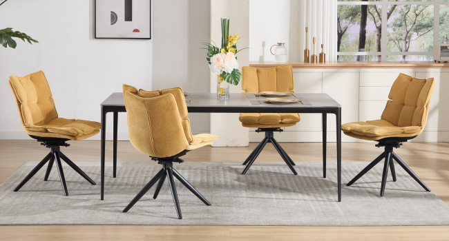 Juego de muebles de comedor modernos con sillas tapizadas en amarillo mostaza y patas de araña de metal negro, que se muestran desde varios ángulos en un ambiente interior luminoso.