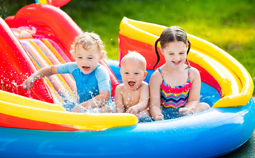 Colorful inflatable children's pool with built-in water slide, featuring bright red, yellow, and blue sections. Water splashing inside.
