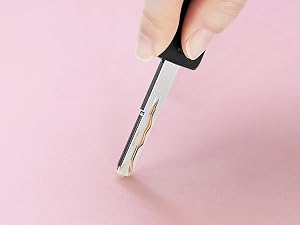 Secuencia de primer plano que muestra un bolígrafo o marcador blanco que se utiliza sobre una superficie de fondo rosa, lo que demuestra su aplicación.