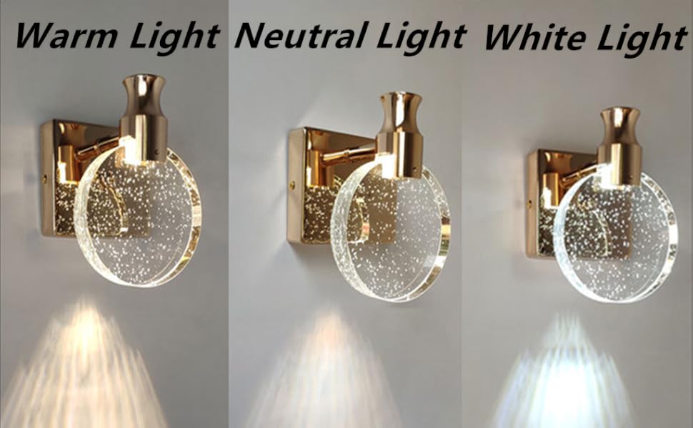 Tres apliques de pared con esferas de cristal que contienen elementos brillantes. Cuenta con ajustes de luz cálida, neutra y blanca con haces proyectados hacia abajo