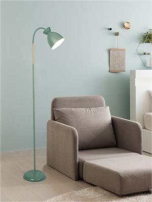 Beiger Sessel mit ausziehbarer Fußstütze, der neben einer mintgrünen Stehlampe in einer minimalistischen Raumgestaltung positioniert